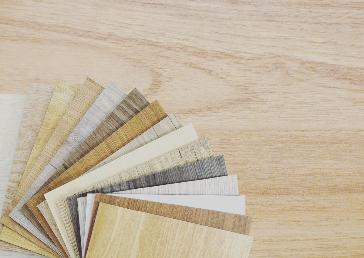 A fan of luxury vinyl plank samples showing the range of oak, walnut and grey wood tones available